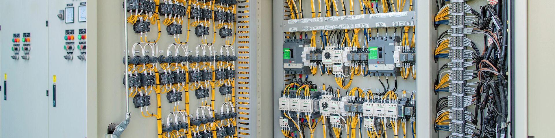 Interior de armario técnico industrial con contactores, llaves termicas, relés y cableado - Vista trasera del panel con pulsadores y señalizadores luminosos - Diagnóstico de instalaciones complejas